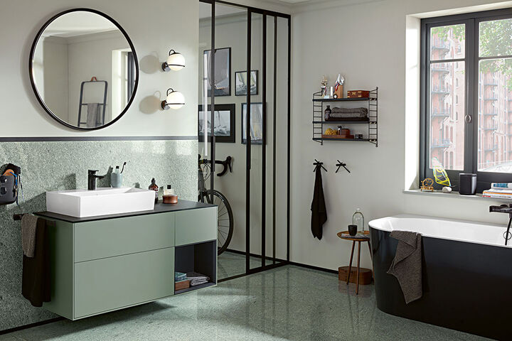 Urbanes Badezimmer von Villeroy & Boch in Grau- und Schwarztönen mit einem Memento 2.0 Waschtisch, Unterschrank und Badewanne.